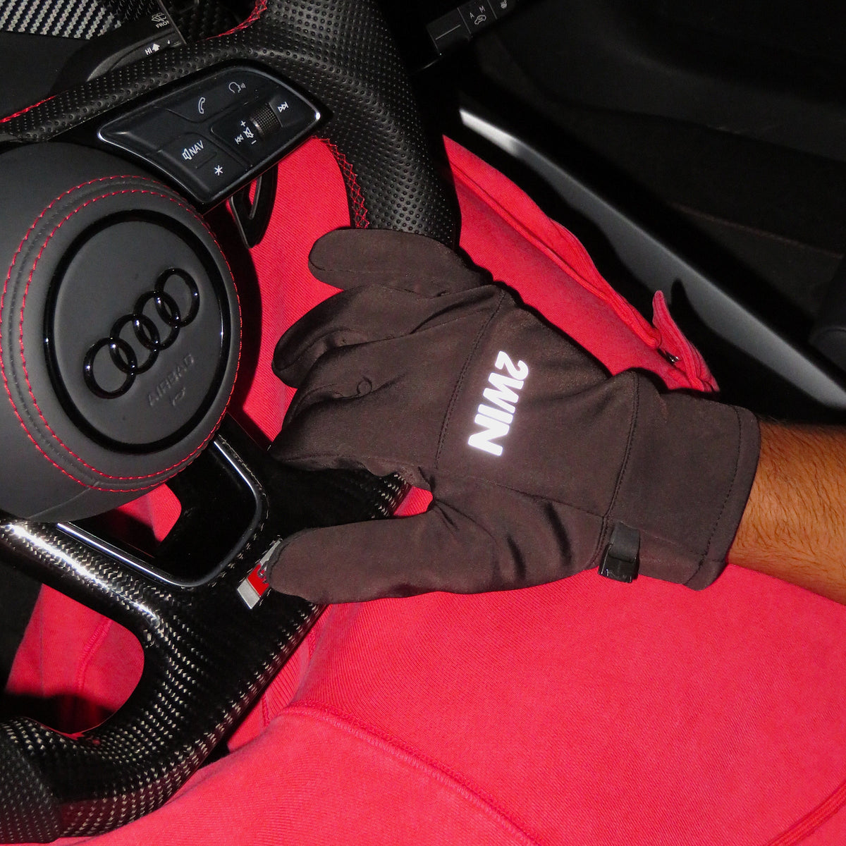 2WIN Driving Gloves worn on the wheel — close fit and reflective wordmark